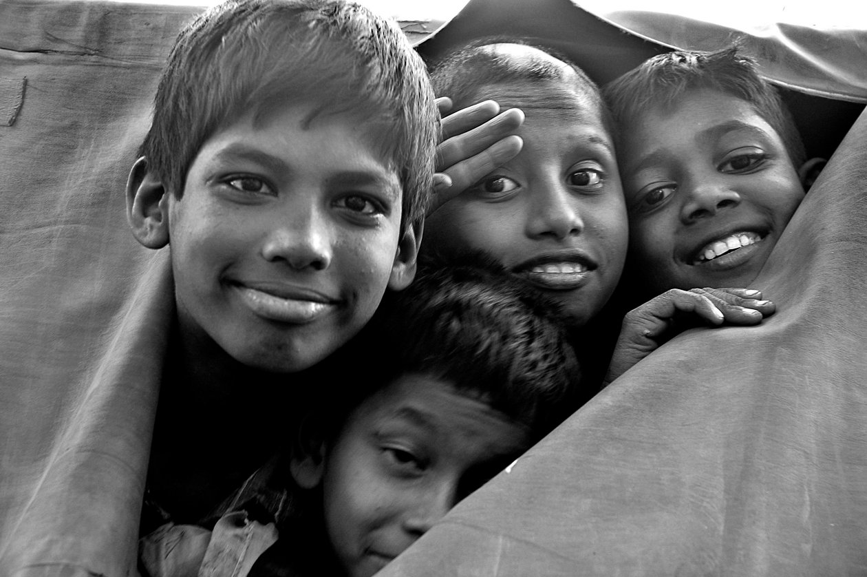 A nyomorgó gyerekek egy rendőrségi furgon szakadt vásznán néznek át a bangladesi Dakka városában. 2006. november 26. alkotó: Unknown