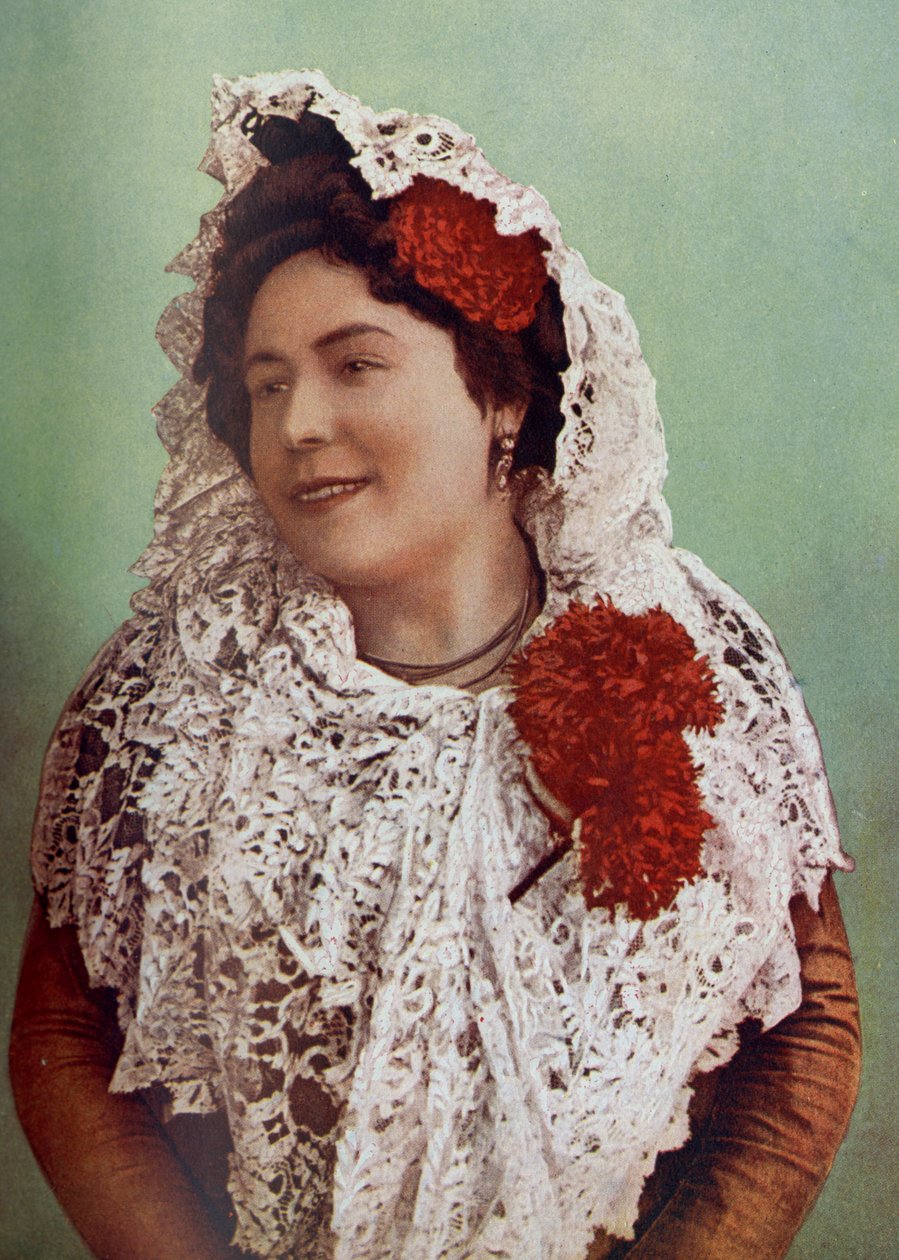 Spanyolország. Skarlát virágok és fehér csipkemantilla a hajra és a vállakra borítva mutatják meg az andalúziai déli szépséget. 1920 alkotó: Unknown