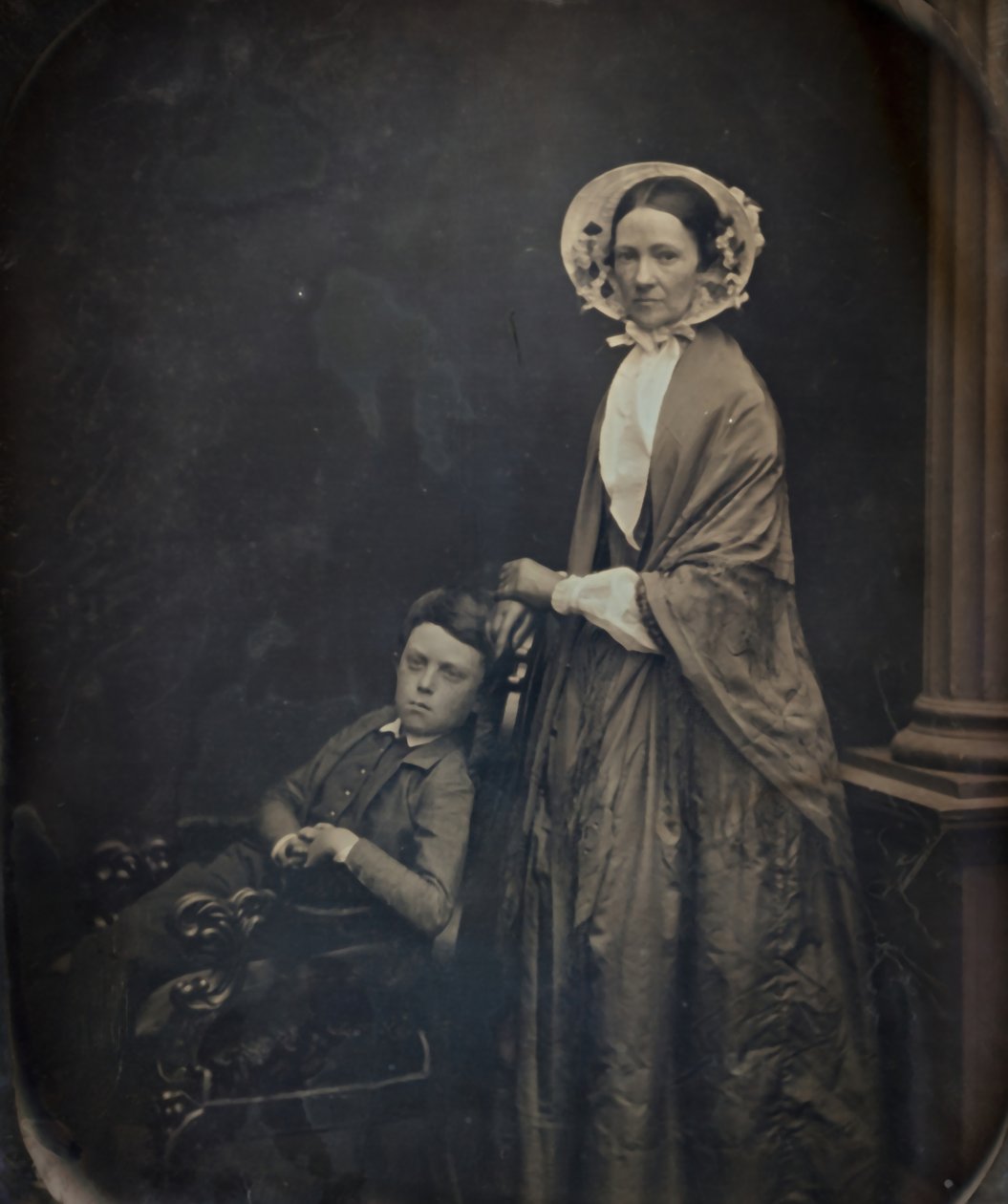 Untitled: A Woman in Bonnet and Shawl, with her Seating Son, c. 1850. Alkotók: Albert Sands Southworth, Josiah Johnson Hawes. alkotó: Albert Sands Southworth, Josiah Johnson Hawes