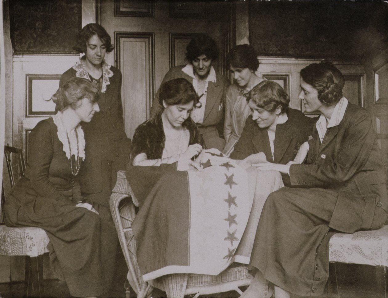 Alice Paul csillagokat varr a választójog zászlójára, ahogy más nők nézik, 1920 körül alkotó: American Photographer