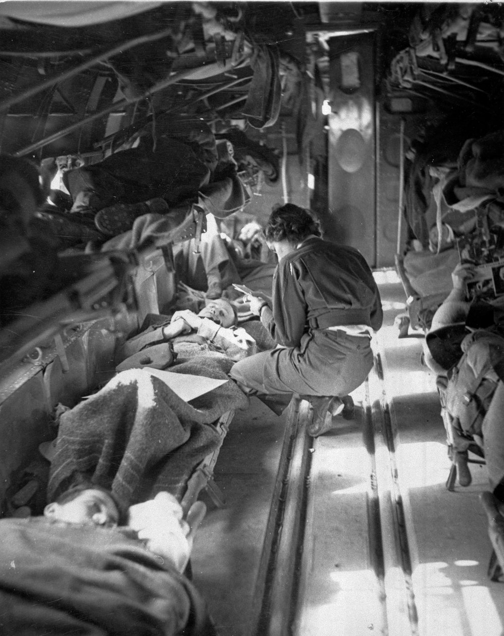 Miss Mary Smith Dél-Karolinából, aki betegeket kezel észak-afrikai repülés közben, 1943-45 körül, a Commando Association által összeállított 650 fényképből álló gyűjteményből alkotó: American Photographer
