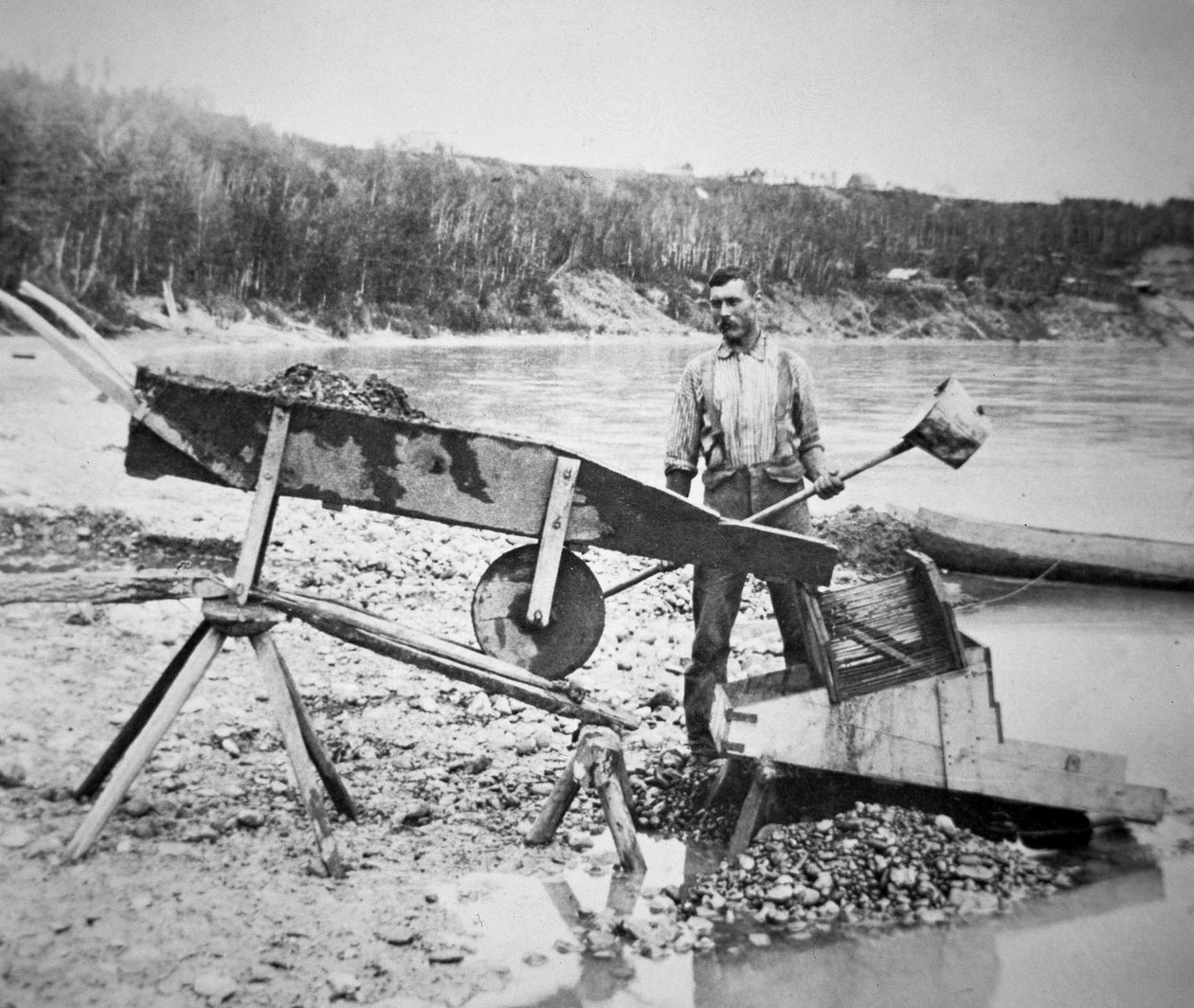 Egy kutató, aki „rockert” vagy „bölcsőt” rak be, hogy aranyat mossa ki a Klondike folyó vizéből a Klondike-i aranyláz idején (1897-98) 1898 (f/w fotó) alkotó: American Photographer