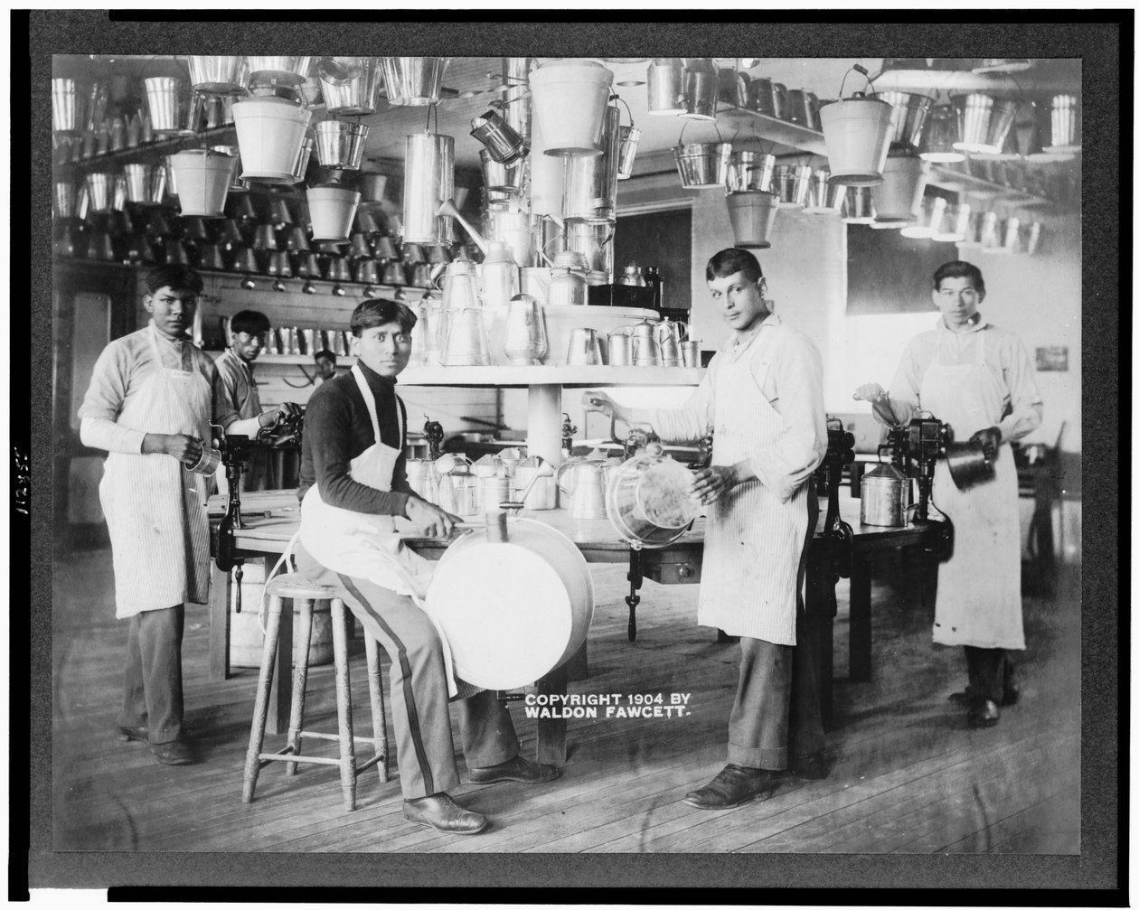 Fiatal indián férfiak fémmegmunkáló műhelyben vödrökkel, mosdókagylókkal, öntözőkannákkal és egyéb fémtárgyakkal, Carlisle Indian School, Pennsylvania, 1904 körül (f/w fotó) alkotó: American Photographer