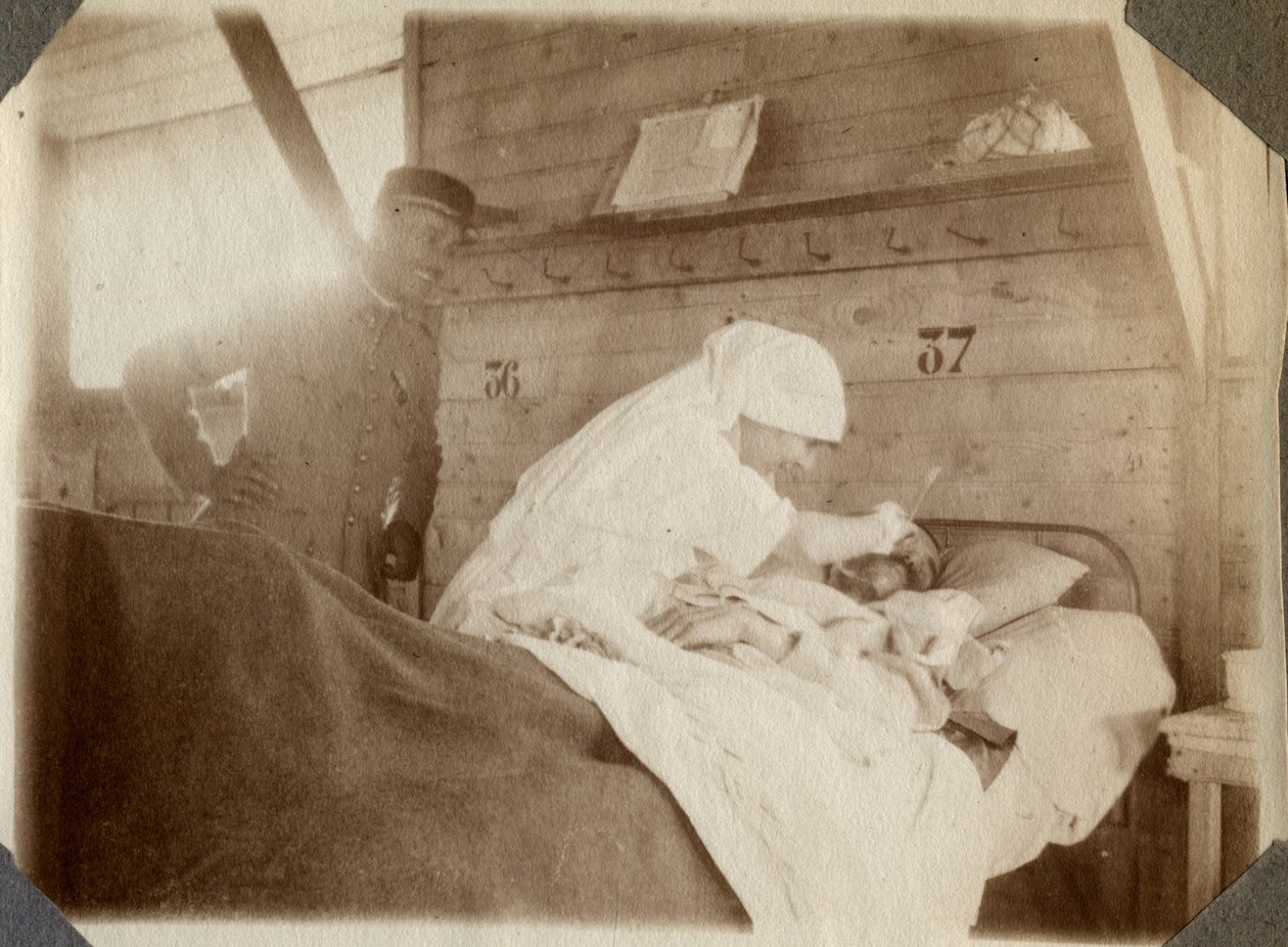 Első világháború 1914-1918: ápolónő blúzban katonát borotvál (a francia háborús sebek ágyban hevernek), Couville-ben, Manche-ban, Alsó-Normandia (Alsó-Normandia), Franciaország. Névtelen fénykép 1917. július. Magángyűjtemény, Stella. alkotó: Anonymous Anonymous