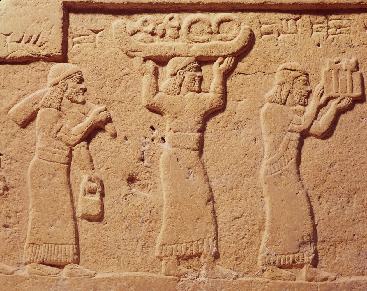Ajándékokkal megrakott hordárokat ábrázoló dombormű alkotó: Assyrian