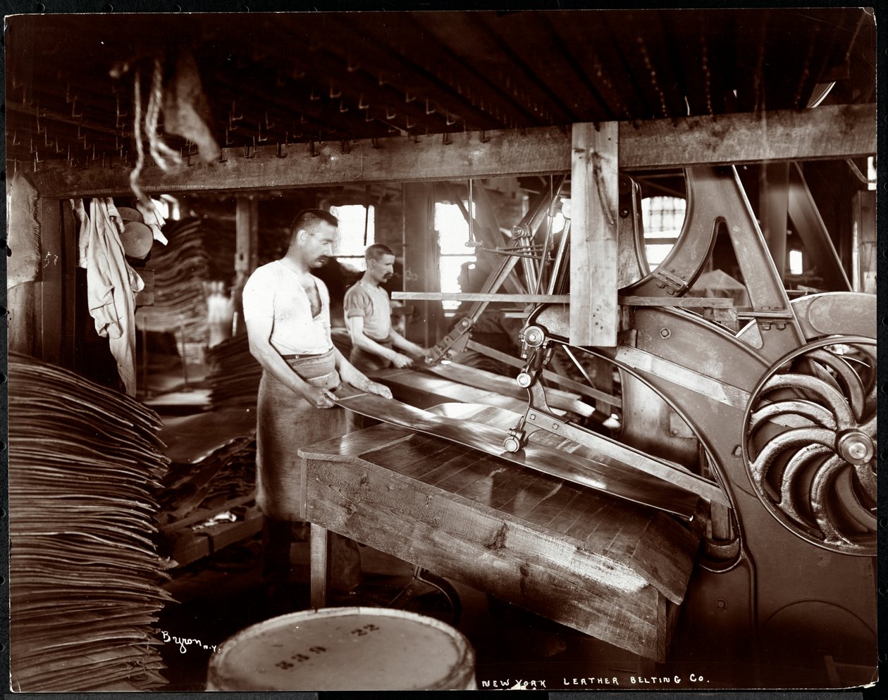 Belső nézet két férfiról, akik bőrrel és nehéz felszerelésekkel dolgoznak a New York-i Leather Belting Co.-nál, New York, 1905 (ezüst zselatin nyomat) alkotó: Byron Company