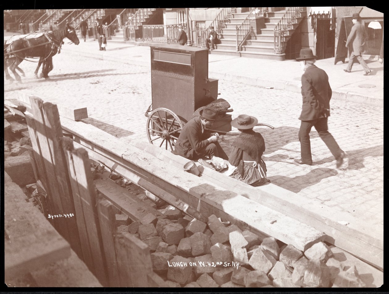Egy utcai orgonista és egy nő képe ebédelni a West 42nd Streeten, New York, 1898 (ezüst zselatin nyomat) alkotó: Byron Company