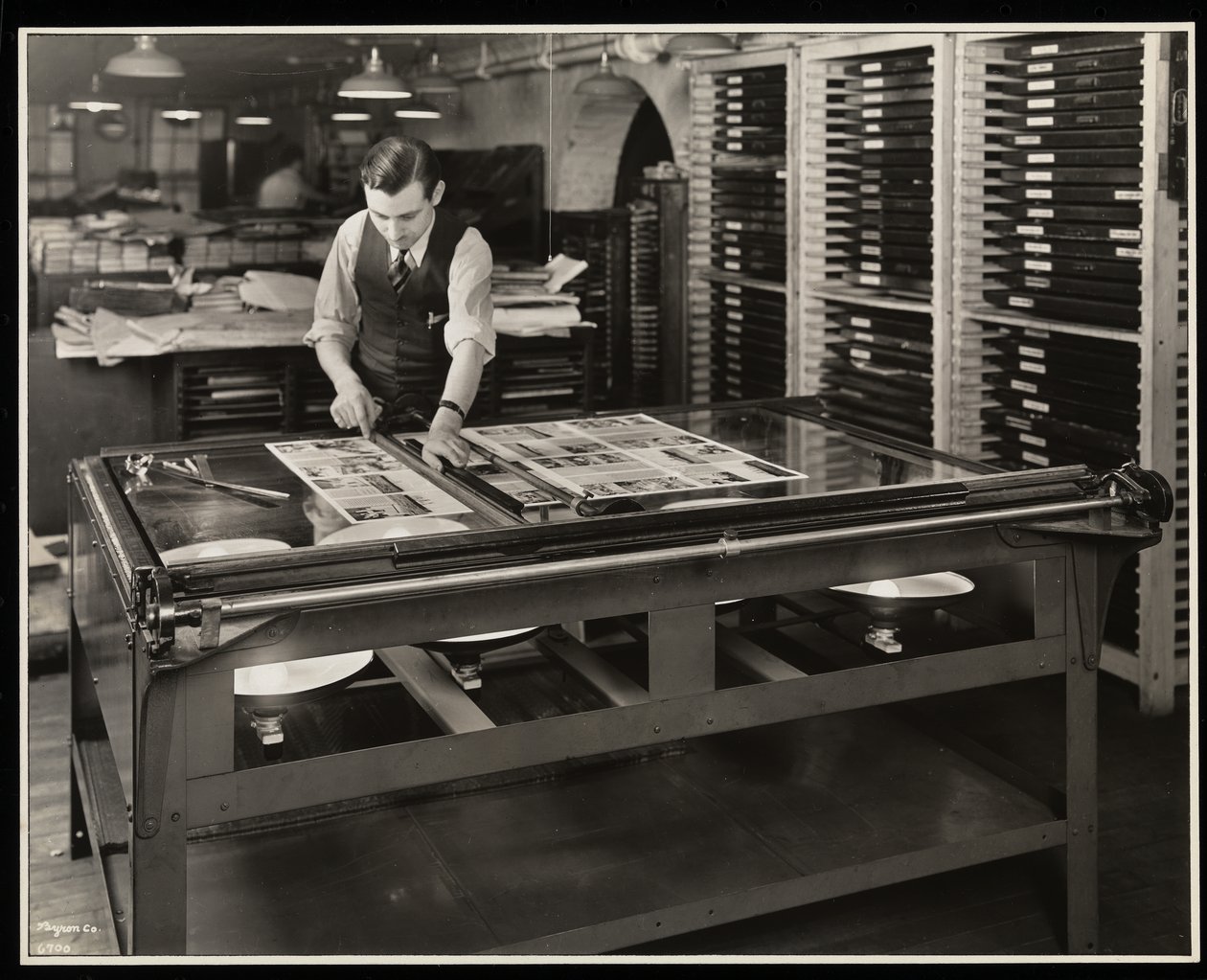 Az Unz und Co., Beaver Street 24, New York, 1932. szám alatti világítóasztalnál dolgozik egy elrendezésen (ezüst zselatin nyomat) alkotó: Byron Company