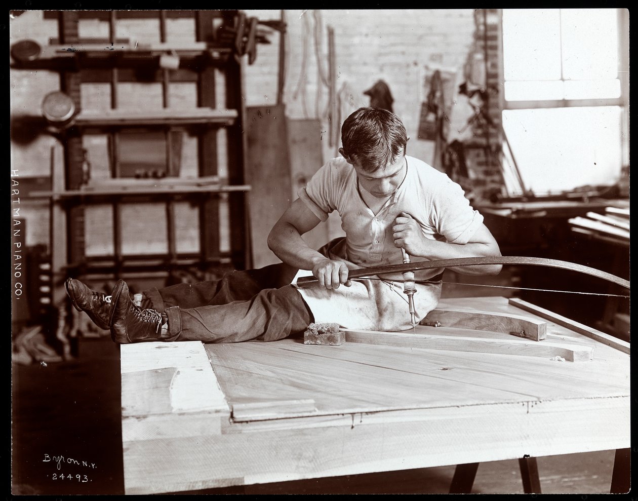 Egy férfi a Hartman Piano Co. gyárában dolgozik, 1907 (ezüst zselatin nyomat) alkotó: Byron Company