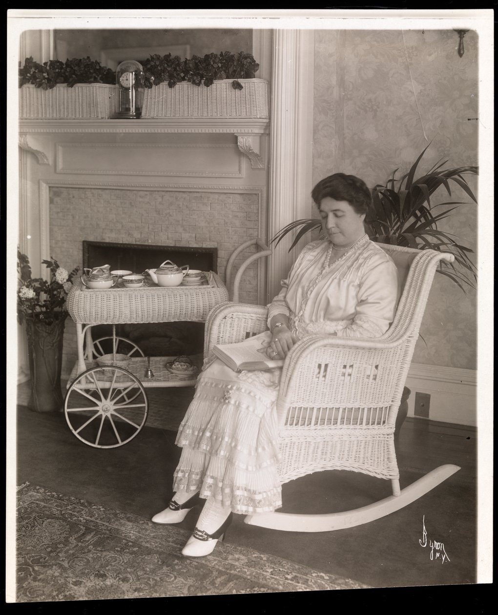 Mrs. Howard egy könyvvel ül egy hintaszékben az 5. sugárút 200. szám alatti otthonában, New York, 1915-6 (ezüstzselatinos nyomat) alkotó: Byron Company