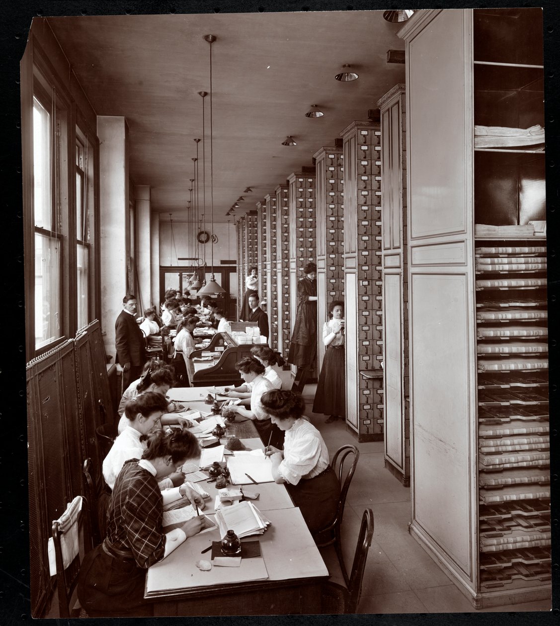 Nők, akik egy irattárban dolgoznak, férfi felügyelete alatt, a Metropolitan Life Insurance Co.-nál, a 23rd Street és Madison Avenue címen, New York, 1907 (ezüst zselatin nyomat) alkotó: Byron Company