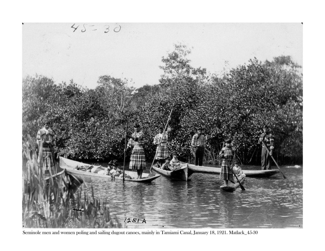 Seminole férfiak és nők ásókenukkal csónakáznak és vitorláznak a Tamiami-csatornán, 1921. január 18. alkotó: Claude C. Matlack
