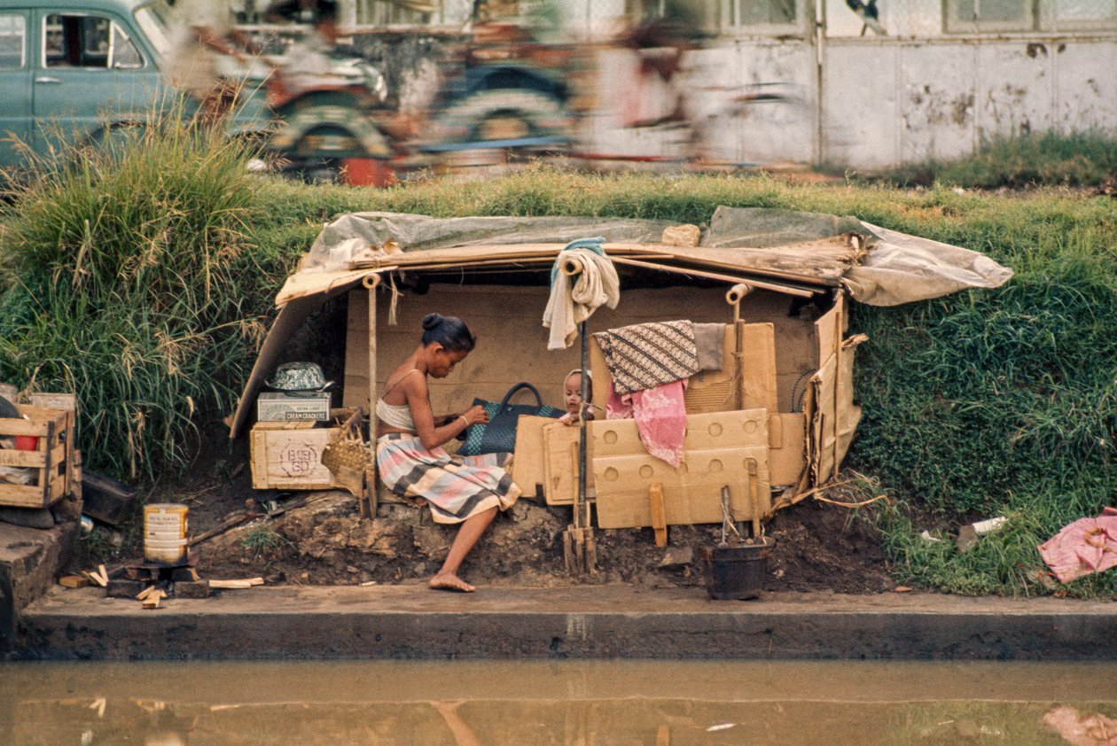 Karton kunyhó, egy szennyvízcsatorna mentén, otthonként szolgál. Jakarta, Indonézia. alkotó: Dean Conger