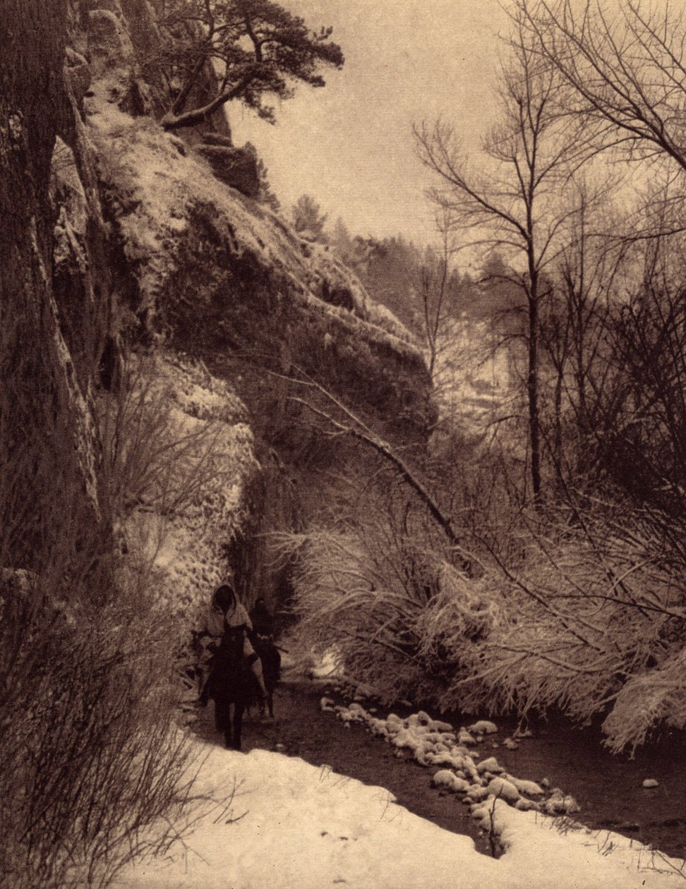Elhaladva a sziklán, téli jelenet. Apsaroke indiánok lovagolnak egy sziklán a hóban a Pryor folyón, Montana. A kép az Edward S. Curtis (1868-1952) által az észak-amerikai indiánokról szóló enciklopédiának 4. kötetéből készült, Theo előszavával alkotó: Edward Sheriff Curtis