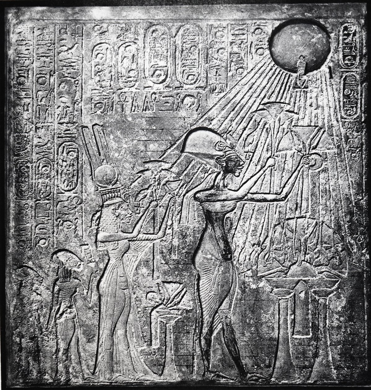 Ehnaton (IV. Amenhotep) eretnek fáraó, Kr.e. 150-től uralkodott, itt Nefertitivel és két lányukkal ajándékoztak a Napnak. Dombormű eredetileg a thébai Nap-templomban. Vászon ruhadarabok alkotó: Egyptian 18th Dynasty