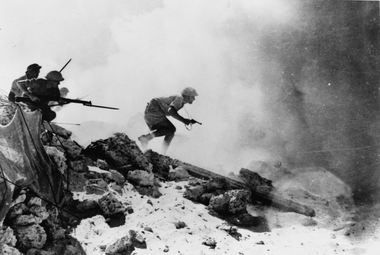 Egy revolverrel felfegyverzett brit tiszt rögzített szuronyokkal vezeti előre embereit, egyike a hét hivatalos fényképnek, amelyek az 1942-es 2. El Alamein-i csatáról szólnak. alkotó: English Photographer
