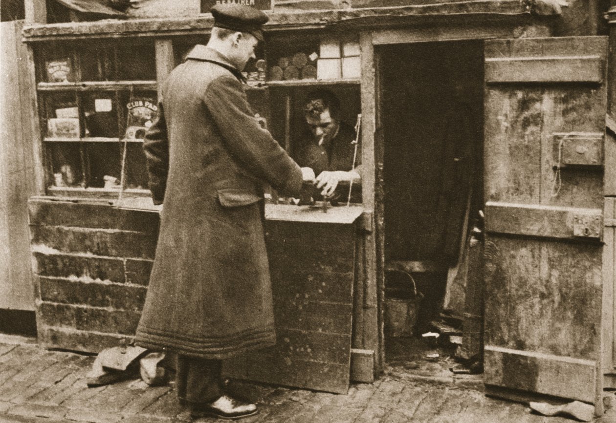 Egy macskaköves Mayfair mews-ben egy rögtönzött fülkében létesített suszter csizmát vesz fel egy sofőrtől, Csodálatos Londonból, 1926-27 (fotómélység) alkotó: English Photographer