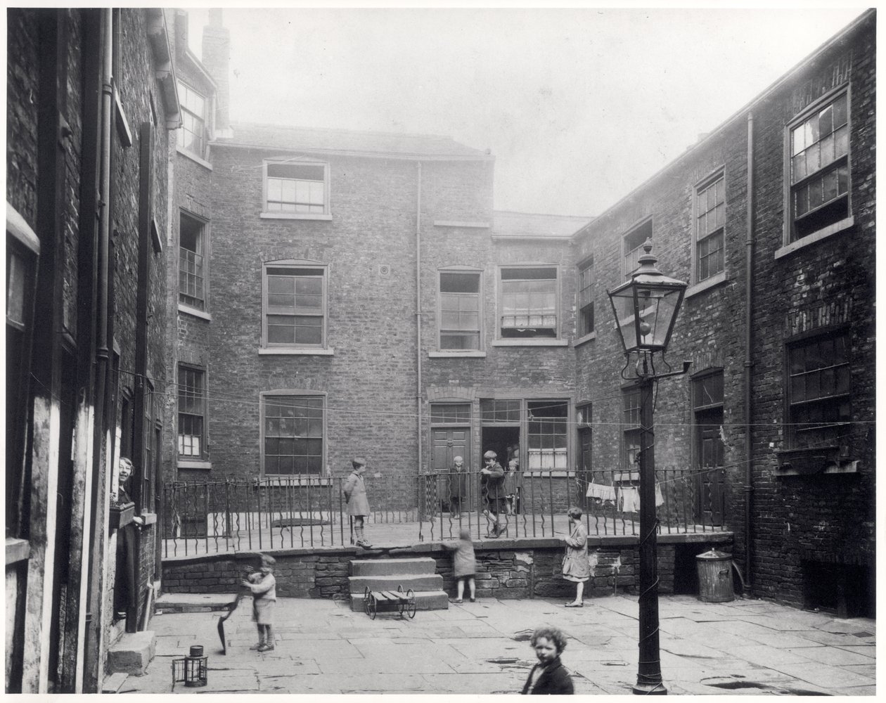Gyerekek játszottak a leedsi Hirst Square-en, mielőtt lebontották, hogy helyet adjon az új polgári teremnek, 1930. július 29. alkotó: English Photographer