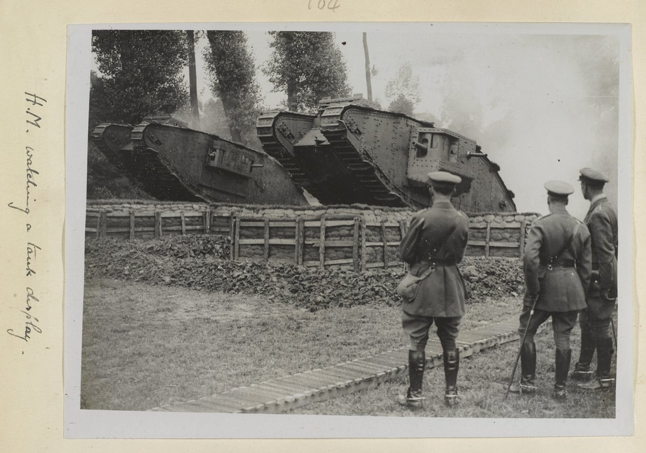 Három tiszt, az egyik feltehetően V. György király, akik két harckocsit néztek, amint áthajtanak egy akadályon, 1915-1818 alkotó: English Photographer