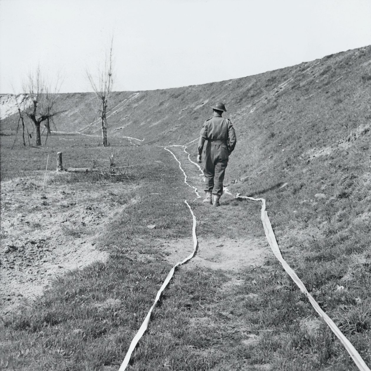 Fehér szalag, amely tiszta nyomokat jelöl egy aknamezőn, a Senio folyó mellett, Olaszország, 1945. március alkotó: English Photographer
