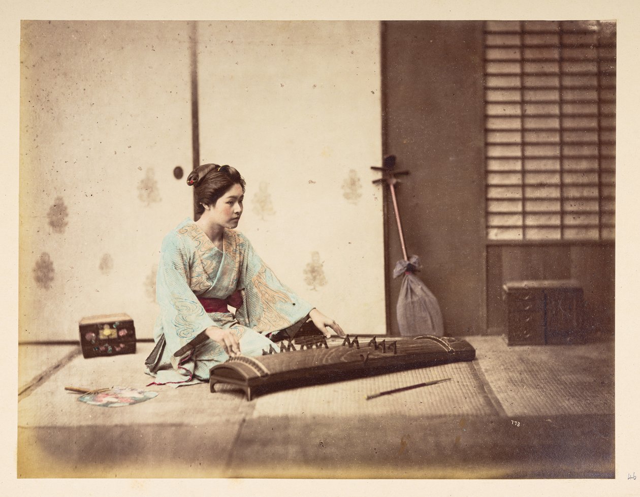 Éneklő lányok [Japán], Tatami szőnyegen ülő fiatal japán nő stúdióportréja, aki vonós hangszeren játszik,  Fotós: Ismeretlen  Lucas Collection: Charles James és Morton P, Lucas világkörüli turnéjának fényképfelvétele alkotó: English Photographer