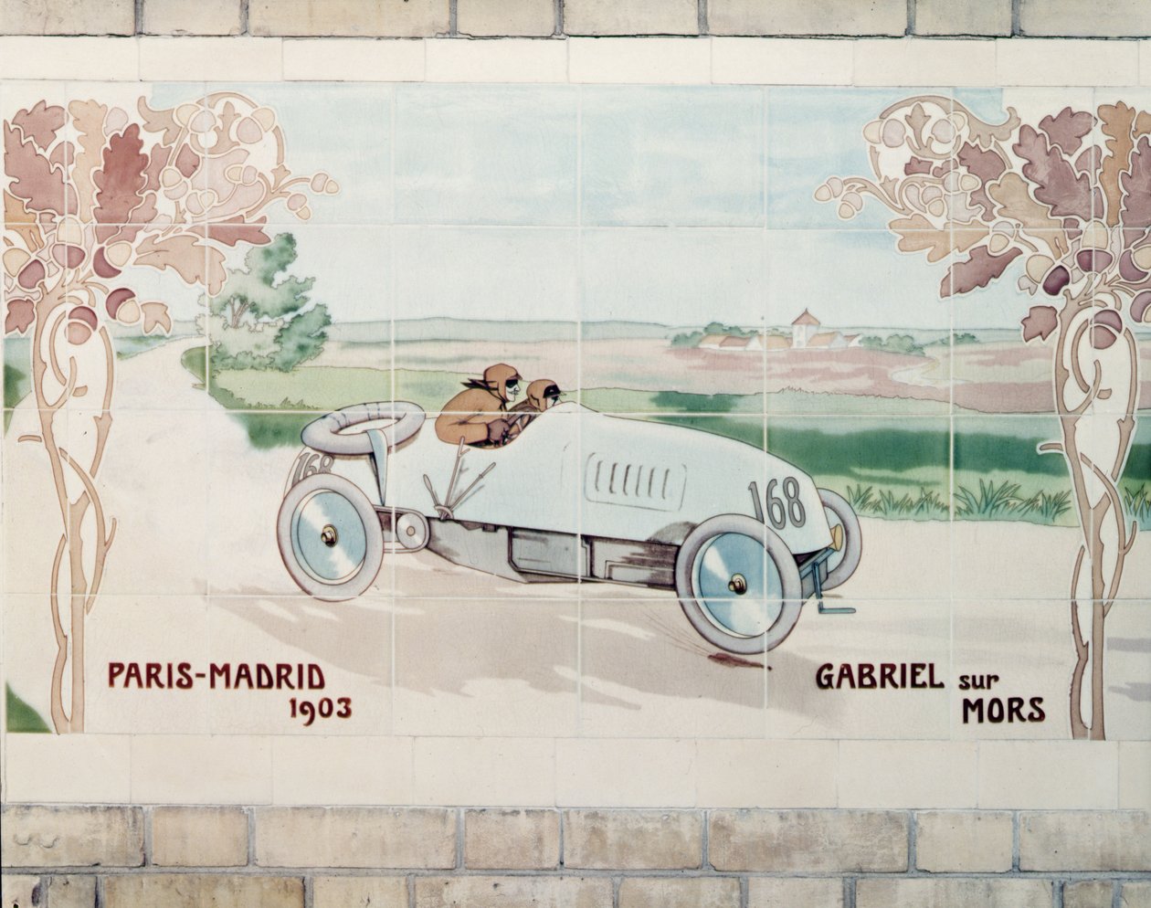 Gabriel egy Mors kocsit vezet az 1903-as Párizs-Madrid versenyen, amely a Halálfutam néven ismert: a párizsi Gilardoni Fils et Cie által gyártott kerámiacsempe Ernest Montaut (1878-1909) rajza után. alkotó: Ernest Montaut