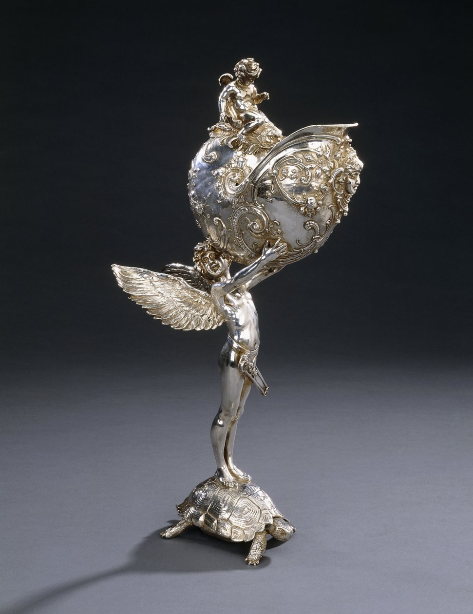 Egy W.M.F. galvanizált bronz szoborvirágtartó, Franz von Stuck terve, teknősbékán álló, nautilus kagylót tartó szárnyas fiatal mintája, 1906 körül alkotó: Franz von Stuck