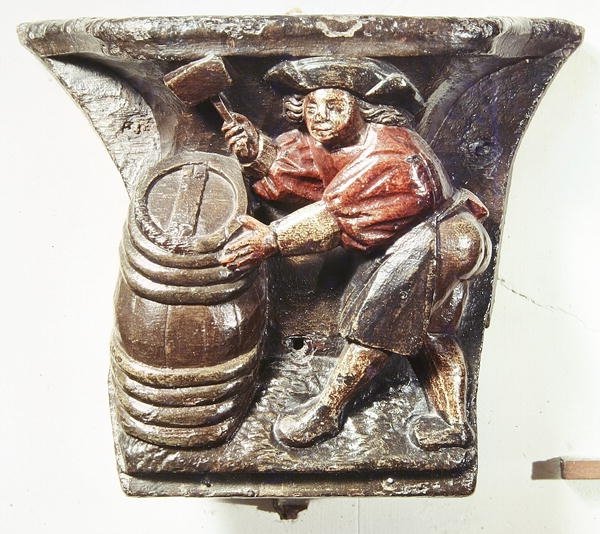 Misericord egy kórusistállóból, amely egy hordót kalapáló férfit ábrázol, a roueni Saint-Etienne des Tonneliers templomból (polikróm fa) alkotó: French School