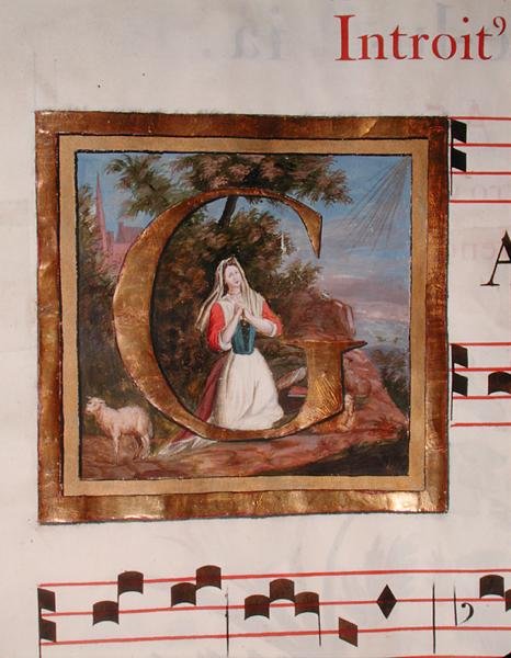 Történelmi kezdetű „G”, amely a nyáját őrző Szent Genevieve-et ábrázolja, egy Szent Genevieve-nek szentelt mise kéziratából alkotó: French School