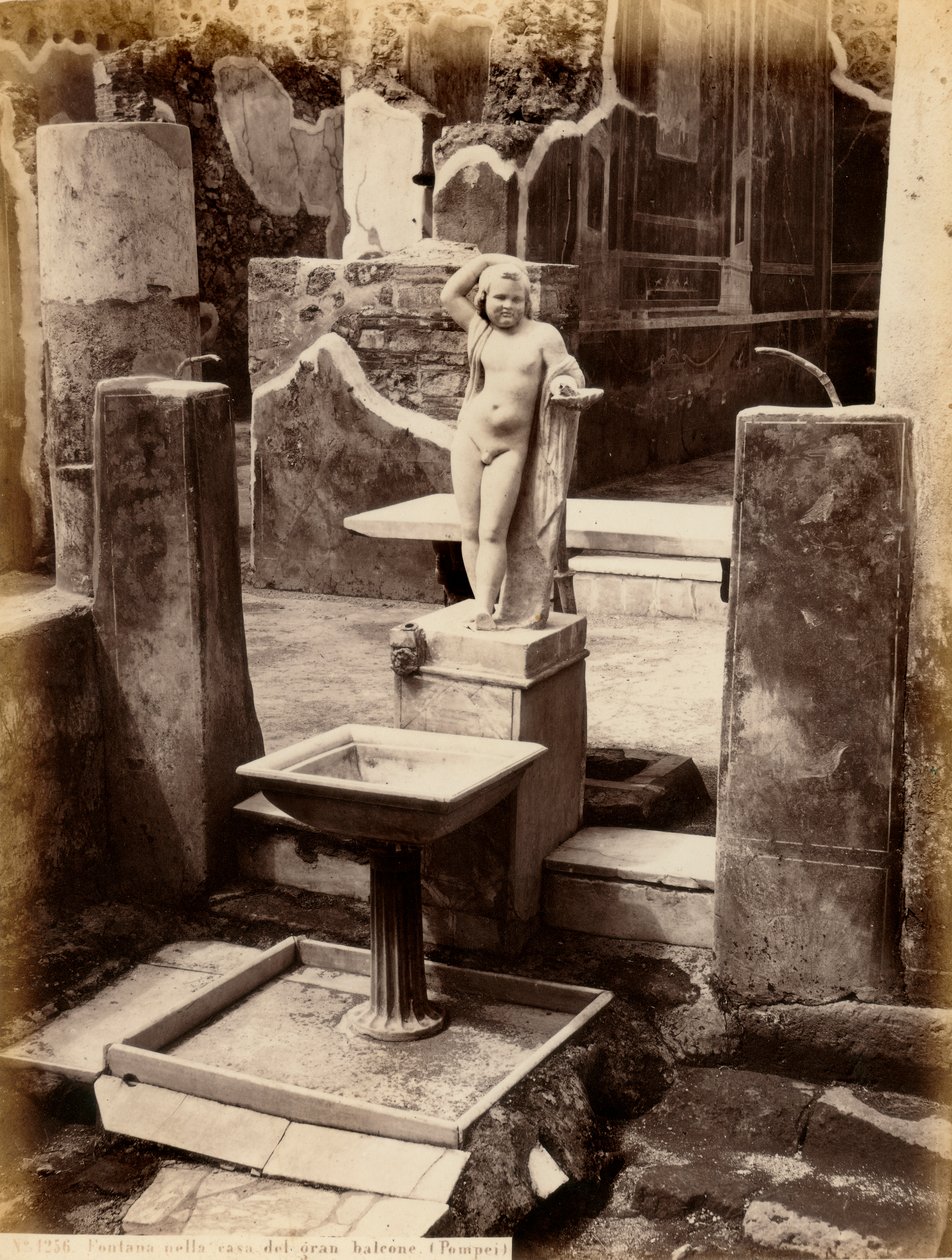 Egy szökőkút, amely egy fiatal fiú akt szobrából áll. A szökőkút a Balcone házában található, Pompeiben alkotó: Giorgio Sommer