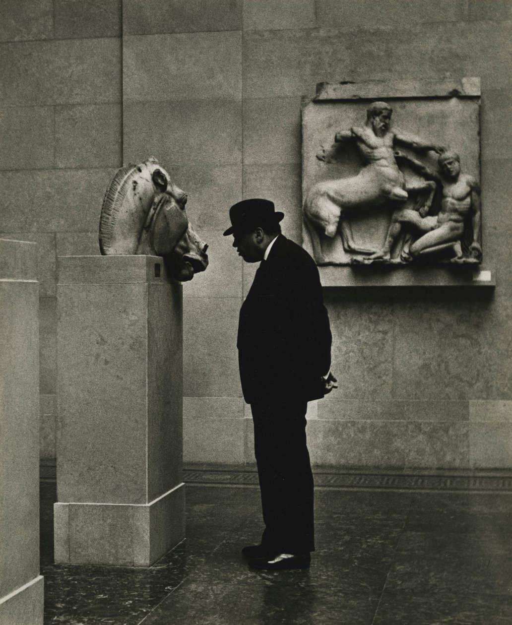 Férfi nézi a British Museumban lévő szobrokat, London 1950-es évek. alkotó: Godfrey Macdominic