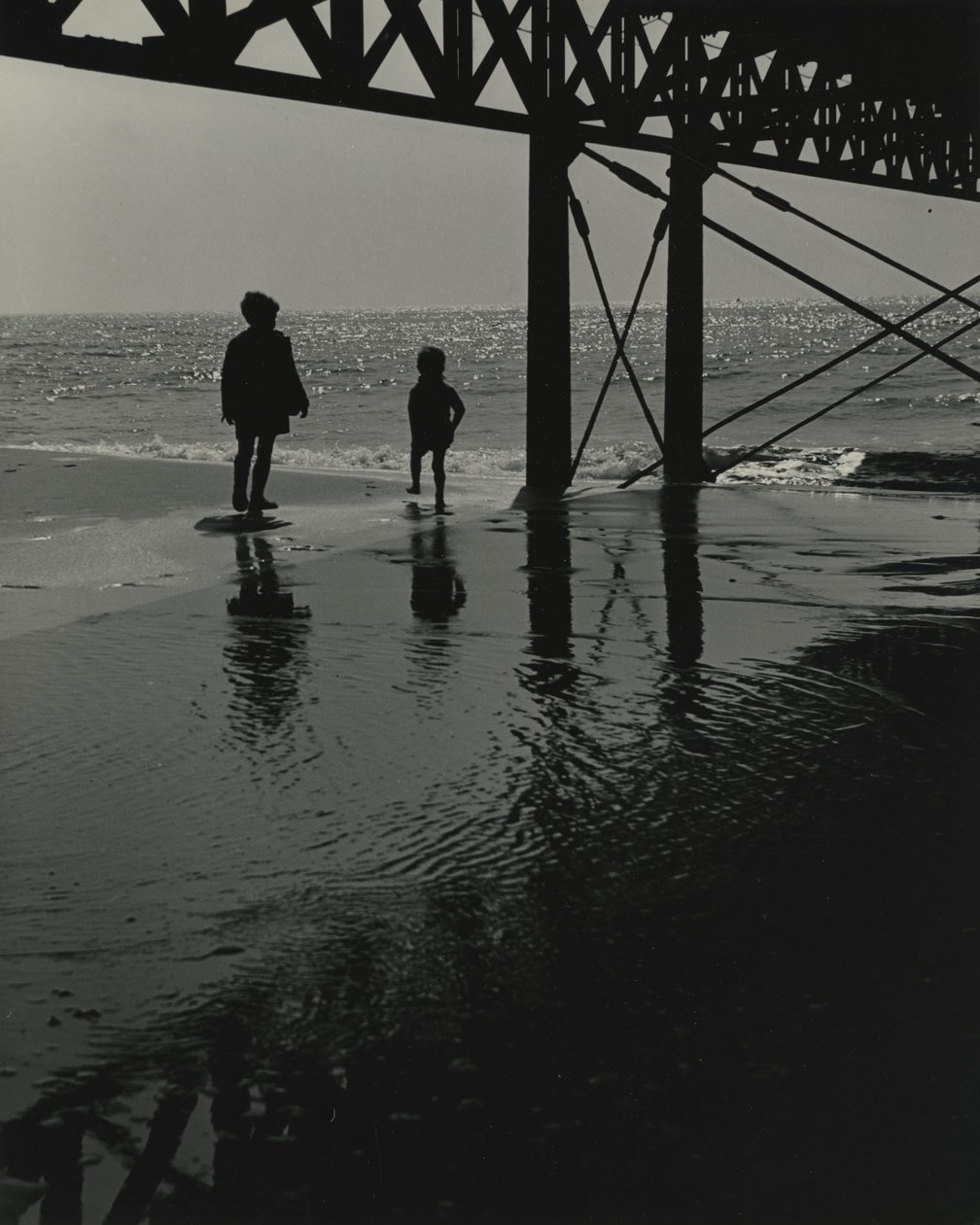 Két gyerek játszik a strandon. alkotó: Godfrey Macdominic