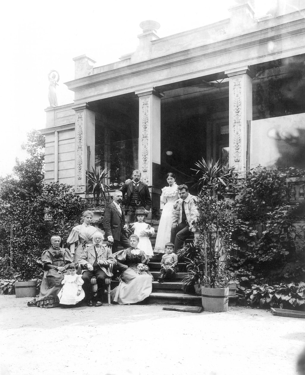 Max Klinger (1857–1920, a bal felső képen) családjával a szülei háza előtt Lipcsében, a Karl-Heine-Strasse 2-ben (kert felőli oldalon) alkotó: Hermann Walter
