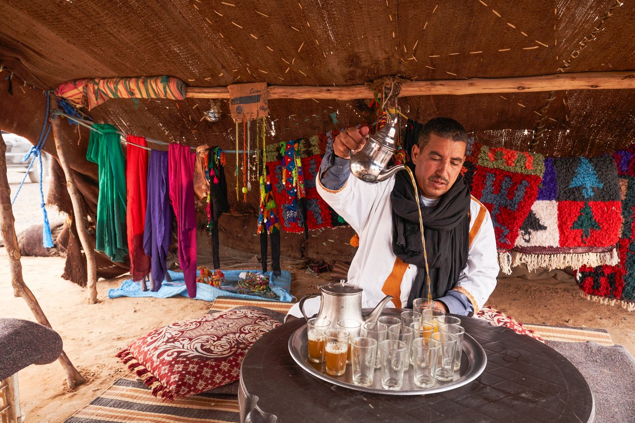 Egy helyi mentateát szolgál fel a marokkói Erg Chebbi sivatagban, Merzouga közelében, Marokkó, 2019 (fotó) alkotó: Ira Block