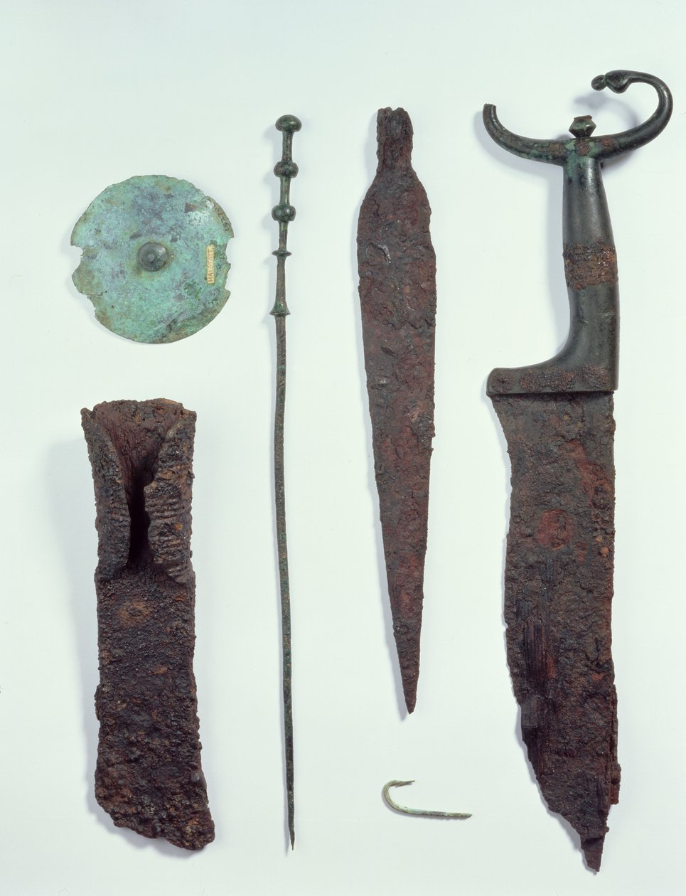 Fentről lefelé: Kés, lándzsahegy, horgászhorog, ruhatű, övkorong és fejsze, mindegyiket a hallstatti férfisírokban találták, vaskorban. alkotó: Iron Age