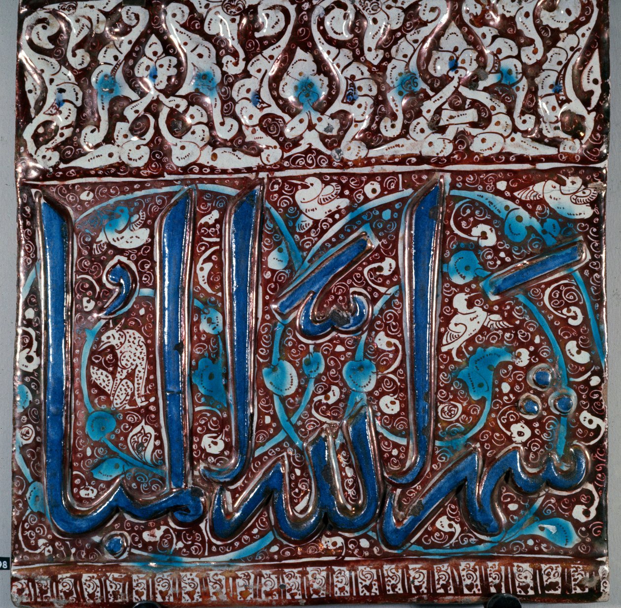 Iszlám művészet: „” lajvardina”” (lapis-lazuli) típusú fali kerámia csempezománc „” The month of God Beni””” felirattal, Kashanból, Iránból. 13. század. Homályos. 36x36 cm Teheráni Régészeti Múzeum, Irán alkotó: Islamic School