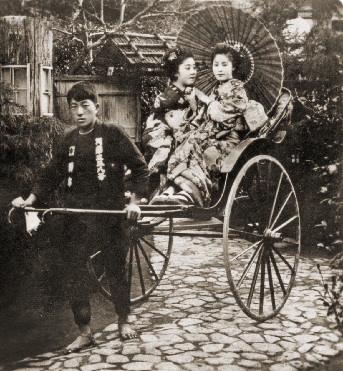 Két gésát húzó futó riksán Japánban, 1900 körül (album fotó) alkotó: Japanese Photographer