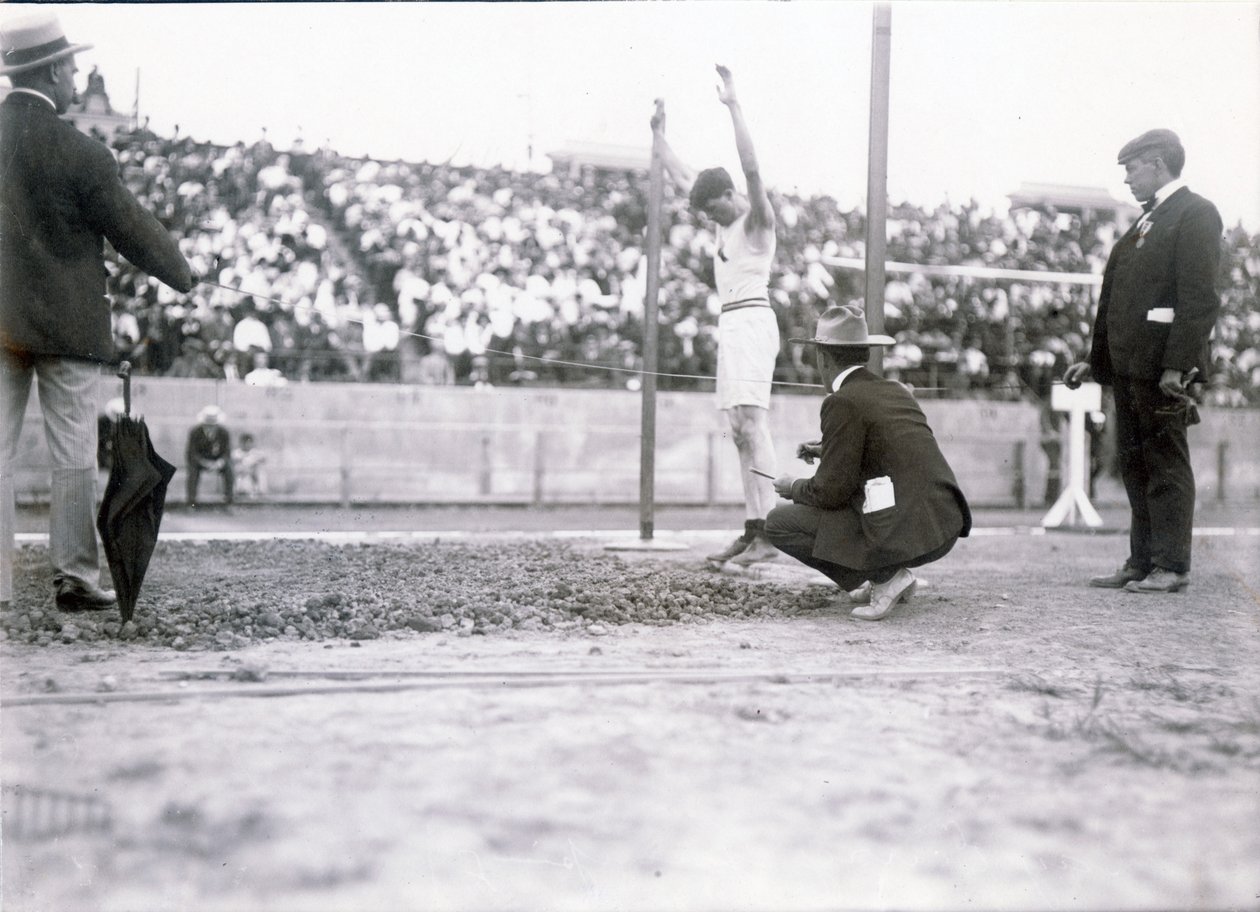 Ray Ewry, a New York -i atlétikai klub tagja, az 1904 -es olimpián álló széles ugrásban versenyez. Ewry nyerte a versenyt alkotó: Jessie Tarbox Beals