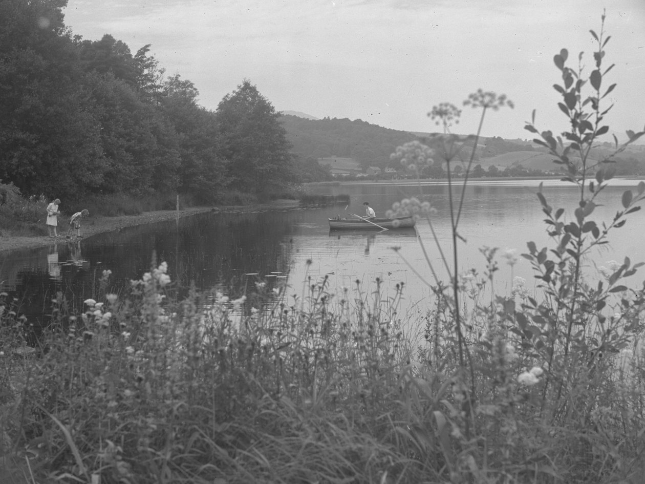 Férfi halászik egy csónakban az Estwaite Water-en és két lány a vízparton alkotó: Joseph Hardman