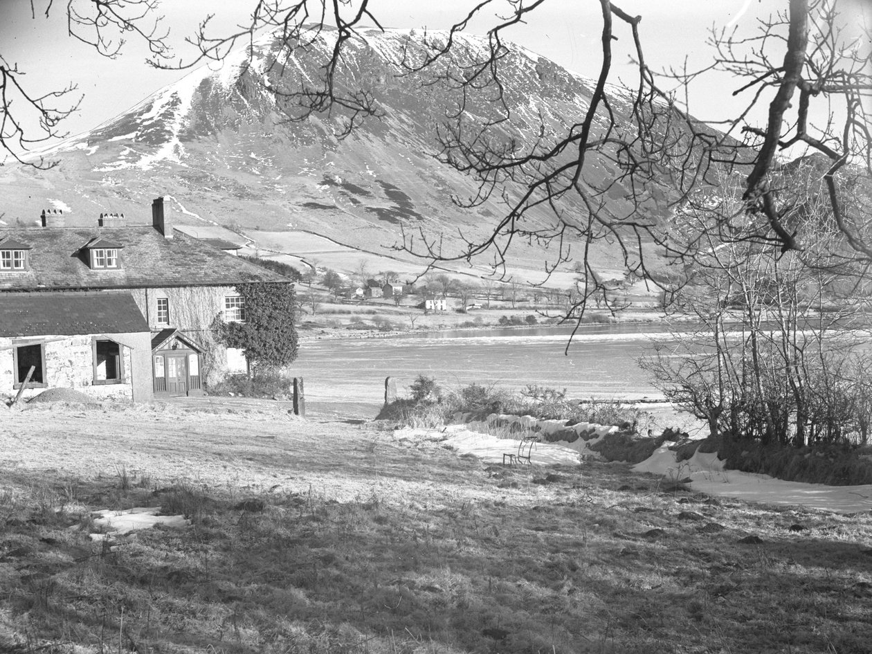 Az Anglers Hotel Ennerdale-ben, előtérben fákkal, a befagyott tó és a havas hegyek mögött. alkotó: Joseph Hardman