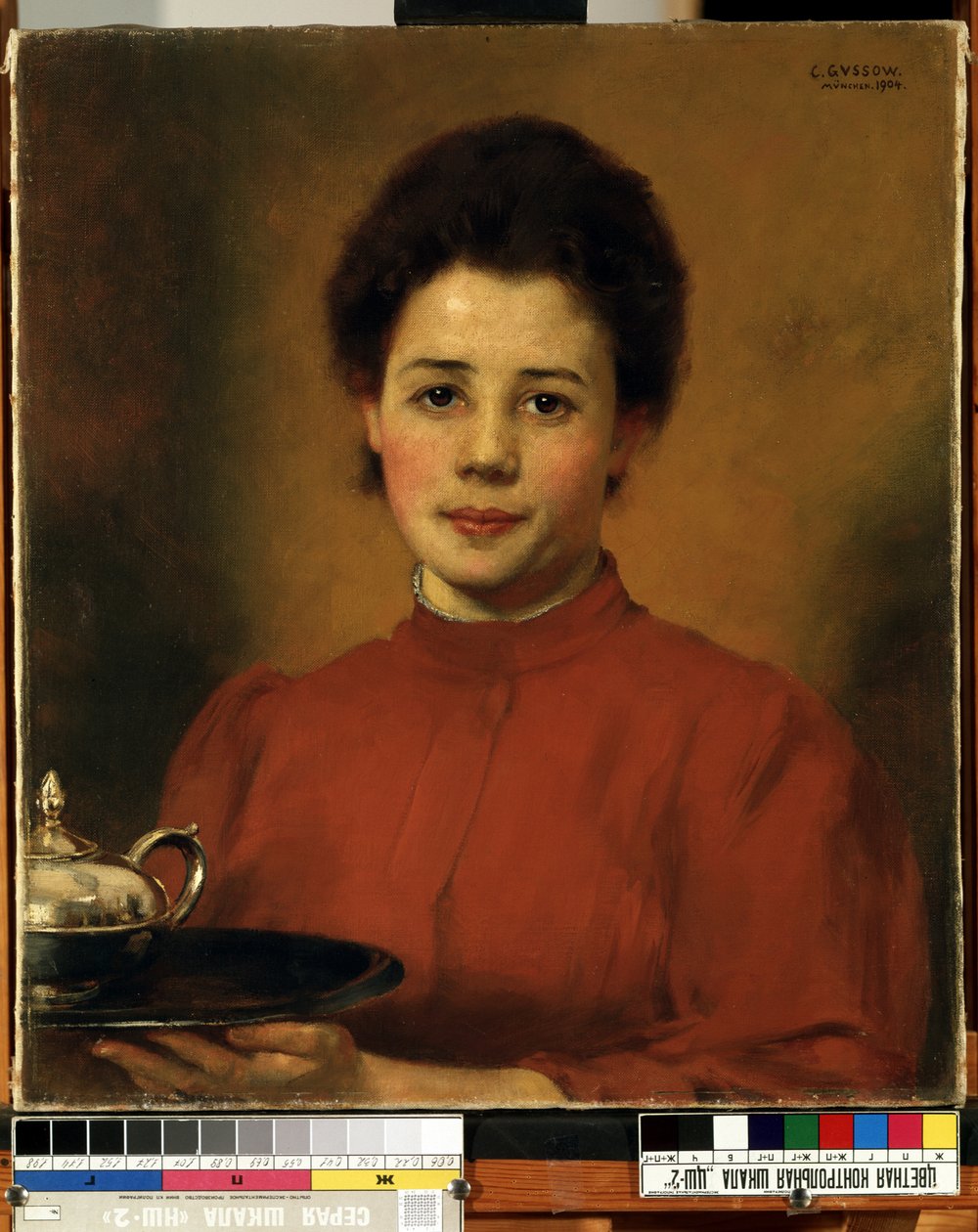 ""Fiatal nő pirosban"" egy nő portréja, aki egy tálcát hordoz egy ezüst teáskannával. (Egy nő pirosban) Karl (Carl) Gusov (1843-1907) festménye 1904 Mikalojus Konstantinas Ciurlionis Szépművészeti Múzeum, Kaunas, Litvánia alkotó: Karl Gussow