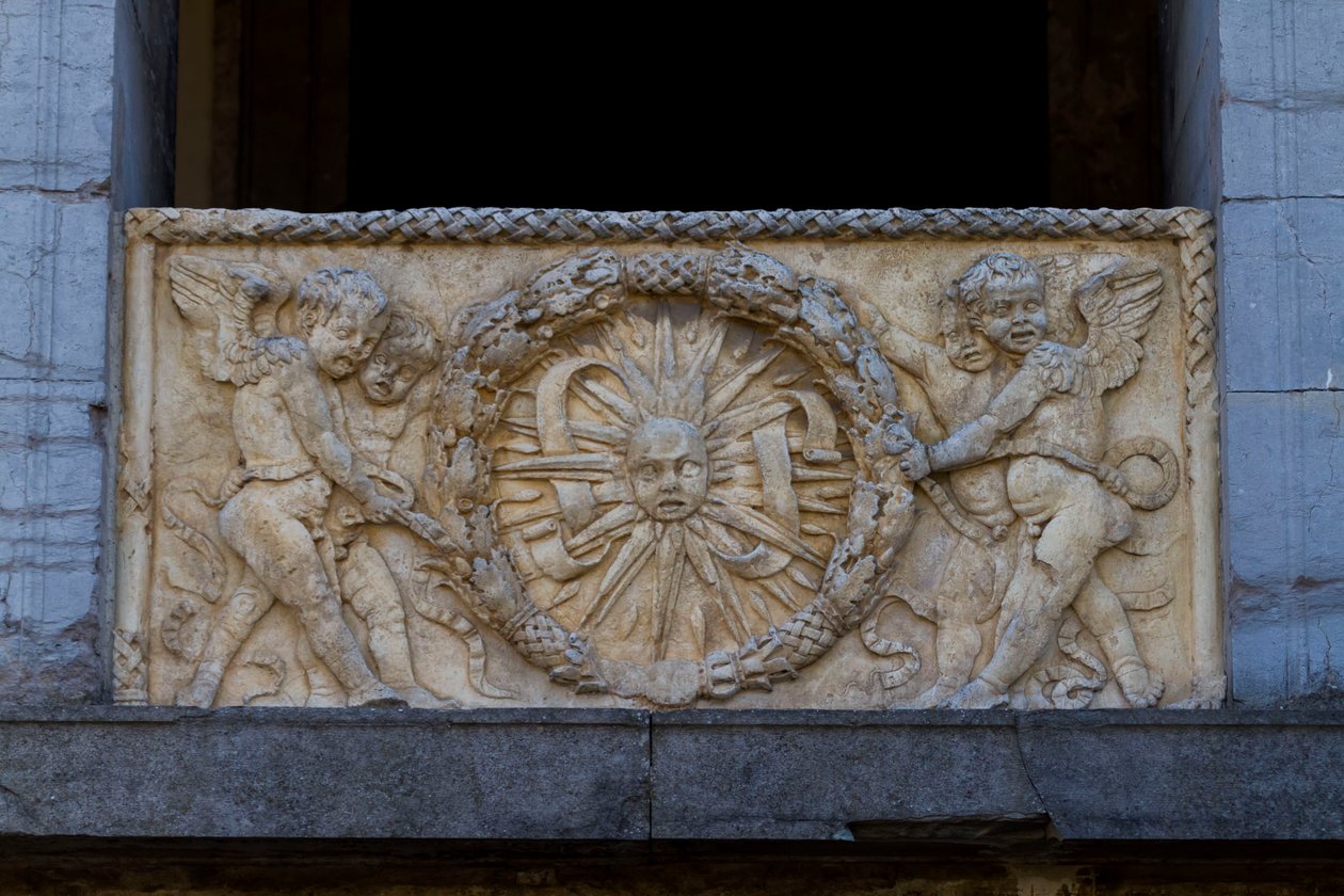 Korlátlemez sugaras nappal füzérben, dombormű a San Sebastiano templom homlokzatán alkotó: Leon Battista Alberti