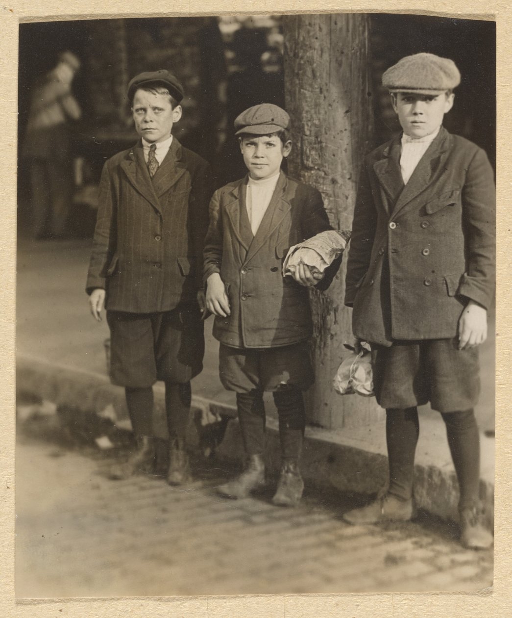 [Három fiú a City Streeten, bugyiban és sapkában] alkotó: Lewis W. Hine