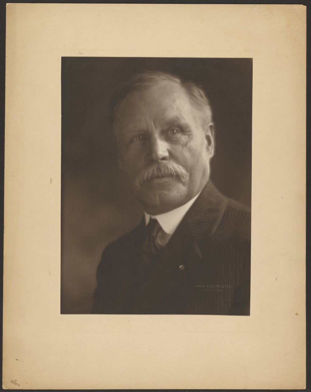 [Egy férfi portréja fém kitűzővel] alkotó: Louis Fleckenstein