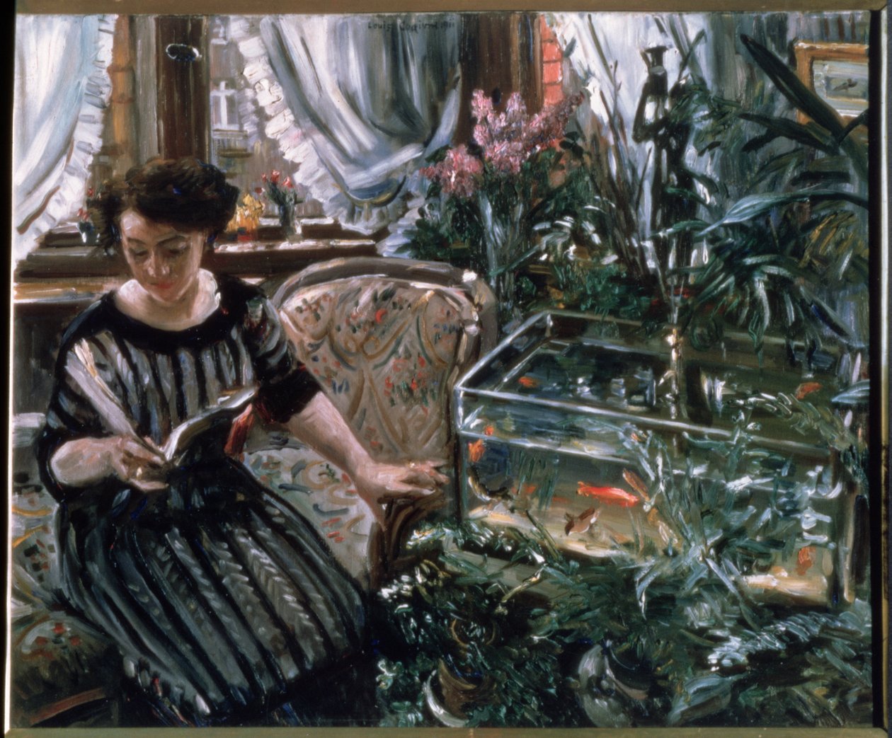 Egy nő olvasás mellett egy aranyhal tartály alkotó: Lovis Corinth