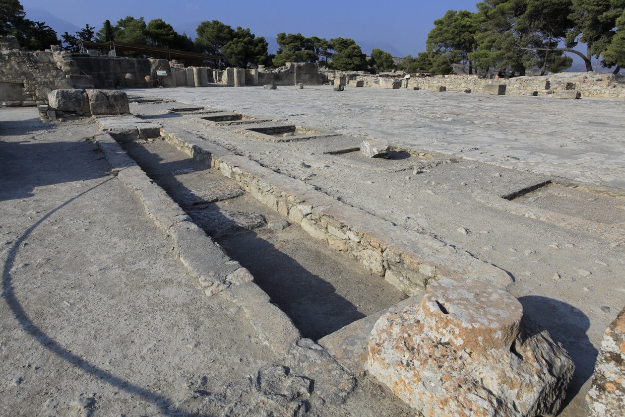Phaistos minószi régészeti lelőhelye. A központi udvar általános képe a nyugati szárny szentélyei felől. A központi udvar a Minoen-palota alapvető építészeti eleme. Ez egy mag, amely köré a különböző szárnyak vannak beállítva. Ez a központi bíróság bui vol alkotó: Minoan