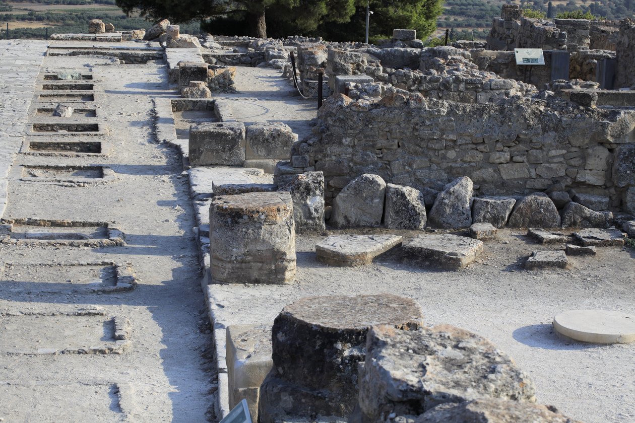Phaistos minószi régészeti lelőhelye. A nyugati szárny szentélyeinek általános képe a központi udvar mentén az északi szárnyból. Kétféle szentély volt: „Padszentély” és „Lutrális medence”. A „pad szentély” egy kicsi és téglalap alakú szoba volt, alacsony b alkotó: Minoan
