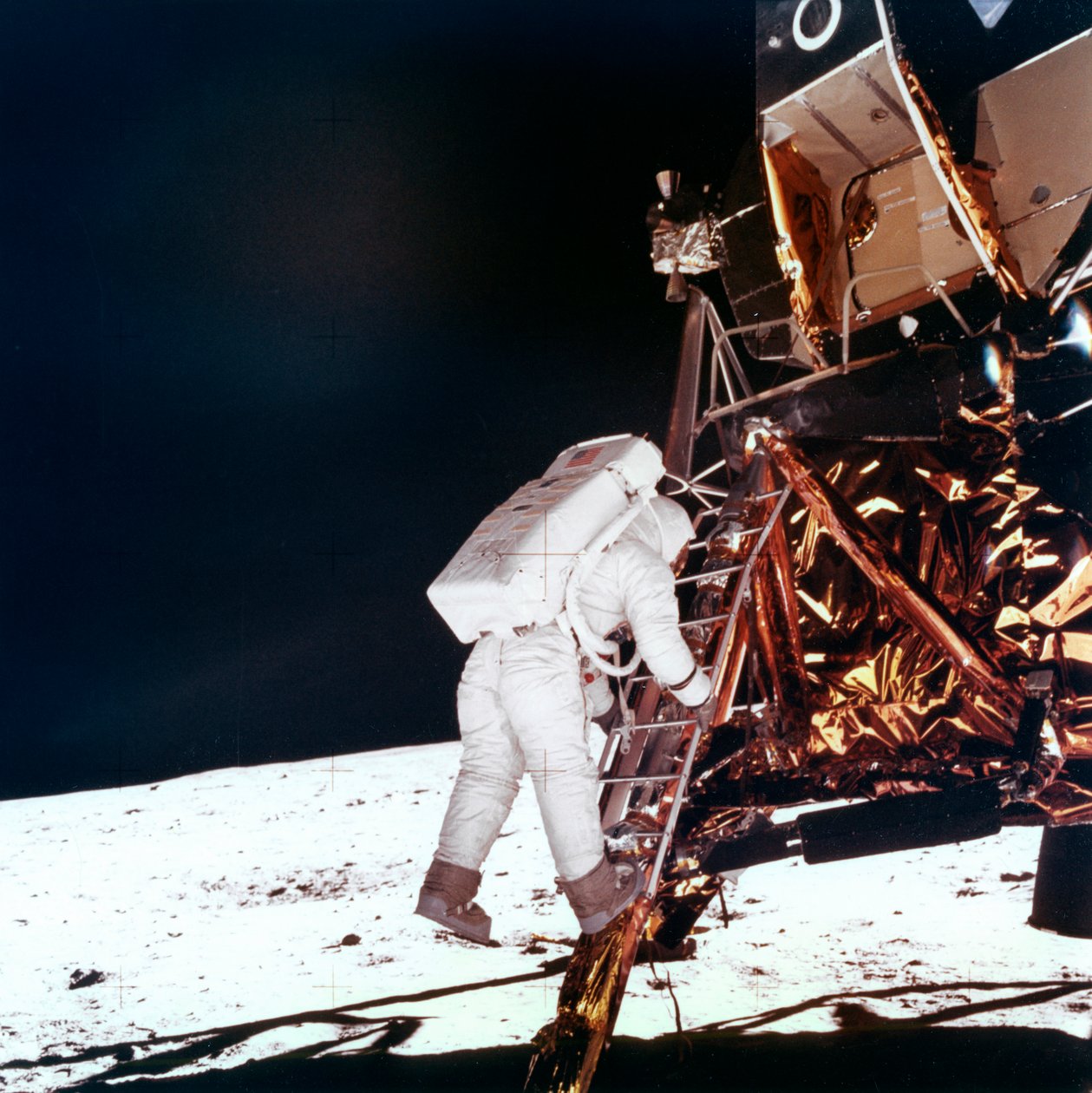 Edwin Buzz Aldrin leereszkedik a Holdmodul létrájának lépcsőin, hogy a Holdon sétáljon, 1969. alkotó: NASA Images
