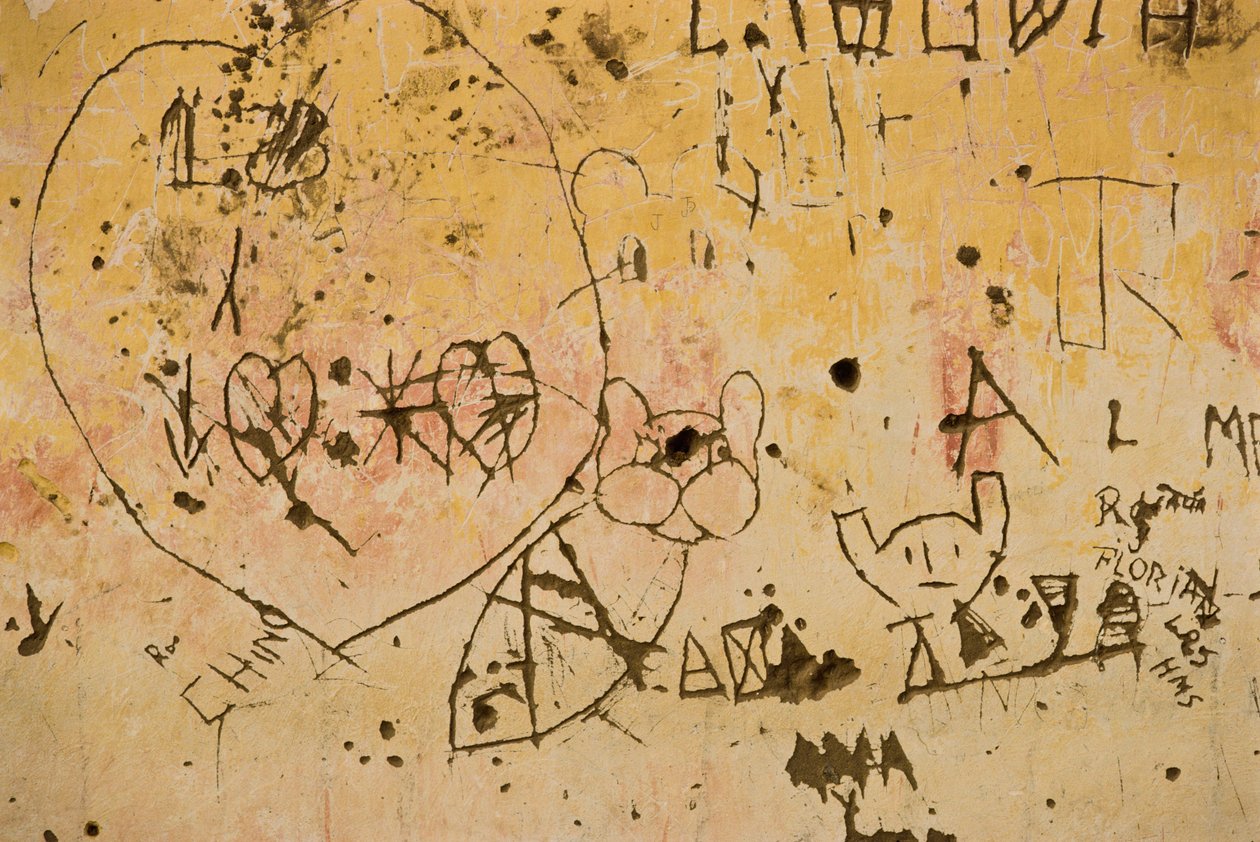 Grafittik egy régi külső vakolatfalba vésve. alkotó: Nathan Benn
