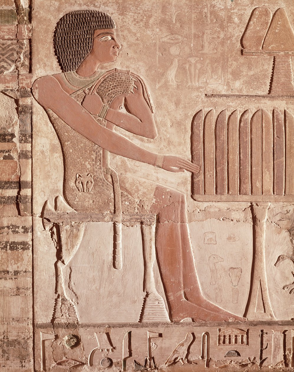 Dombormű, amely az elhunytat kenyérrel (festett kő) kínáló asztal előtt ülve ábrázolja alkotó: Old Kingdom Egyptian
